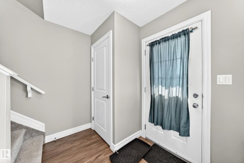 Entryway featuring wood-finish flooring, light gray walls, and white trim - 10-415 Clareview Rd Nw Nw, Edmonton, AB 