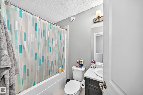 Bathroom featuring a white tub, light gray walls, a dark gray vanity with a white countertop, an undermount sink, and an overhead vanity light fixture - 415 Clareview Rd Nw Nw, Edmonton, AB - Indoor Photo Showing Bathroom