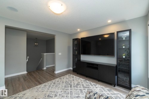 Contemporary living space featuring wood-finish flooring and light gray wall paint - 923 Mcconachie Boulevard, Edmonton, AB 
