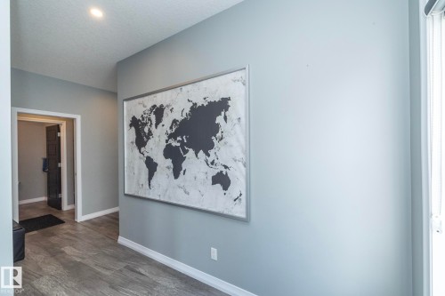 Hallway with recessed lighting, light gray walls, wood-finish flooring, and white baseboards - 923 Mcconachie Boulevard, Edmonton, AB 