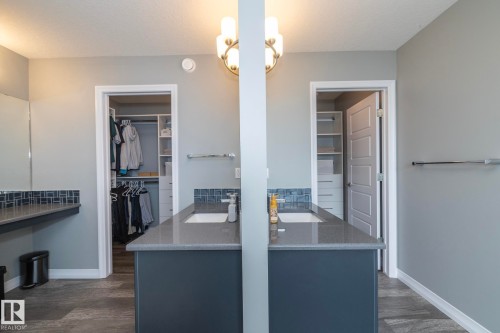 Dual vanity featuring undermount sinks, stone countertops, and blue mosaic tile backsplashes - 923 Mcconachie Boulevard, Edmonton, AB 