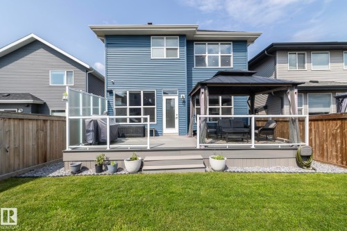 Spacious backyard featuring a composite deck with glass railings, a dedicated gazebo area, and a privacy wall - 923 Mcconachie Boulevard, Edmonton, AB 