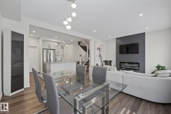 Open-concept living space featuring wood-finish flooring, recessed lighting, and a modern linear fireplace - 