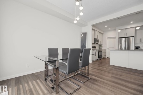 Open-concept living space featuring wood-finish flooring, white walls, and recessed lighting - 432 Roberts Crescent, Leduc, AB 