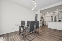 Open-concept living space featuring wood-finish flooring, white walls, and recessed lighting - 