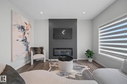 Living area featuring a dark accent wall with a built-in electric fireplace, recessed lighting, wood-finish flooring, and a large window with horizontal blinds - 