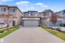 Modern two-story residence featuring a paved driveway, integrated garage, and stone facade accents - 432 Roberts Crescent, Leduc, AB 