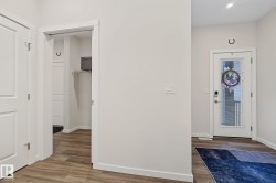Foyer with wood-finish flooring, white trim, and light-colored walls - 