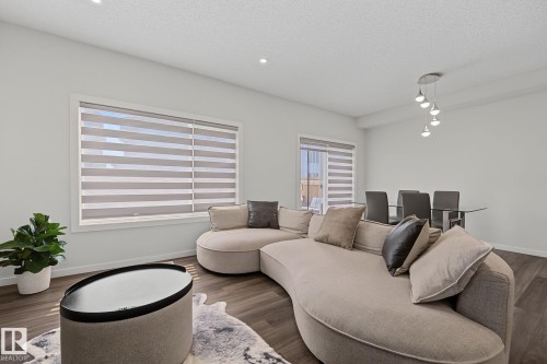 Open-concept living area with dark wood-finish flooring - 432 Roberts Crescent, Leduc, AB 