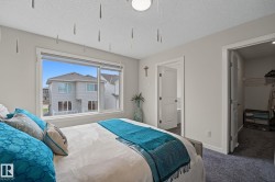 Spacious room featuring a large window with white trim, soft gray wall paint, and plush carpet flooring - 