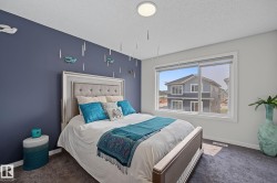 Bedroom featuring a large picture window, a textured carpet, and a flush-mount ceiling light - 