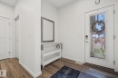 Entryway featuring wood-finish flooring, white baseboards, and a white interior door with a full-lite glass insert and a digital lock - 432 Roberts Crescent, Leduc, AB 