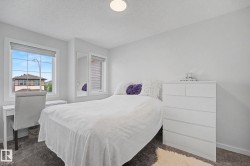 Carpeted bedroom featuring two windows, neutral wall tones, and a flush-mount ceiling light - 