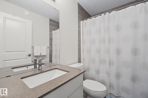 Bathroom vanity featuring a light-toned countertop with an integrated sink and chrome faucet - 432 Roberts Crescent, Leduc, AB 