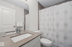 Bathroom vanity featuring a light-toned countertop with an integrated sink and chrome faucet - 