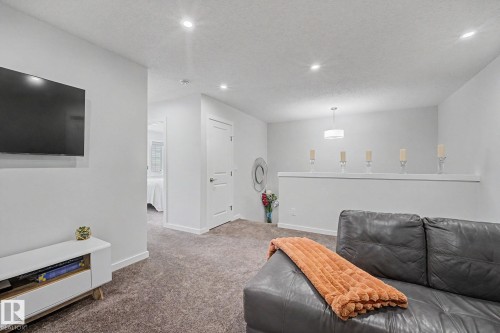 Carpeted living area featuring recessed lighting and a contemporary ceiling fixture - 432 Roberts Crescent, Leduc, AB 