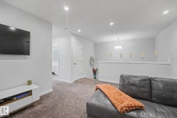 Carpeted living area featuring recessed lighting and a contemporary ceiling fixture - 