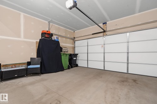 Spacious garage featuring a concrete floor, an overhead garage door, and an automatic garage door opener - 432 Roberts Crescent, Leduc, AB 
