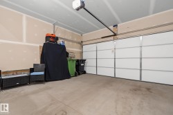 Spacious garage featuring a concrete floor, an overhead garage door, and an automatic garage door opener - 