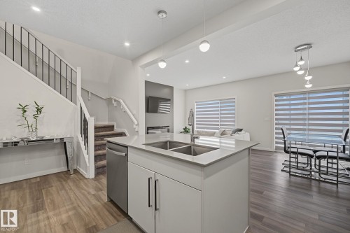 Open-concept living space with wood-finish flooring throughout - 432 Roberts Crescent, Leduc, AB 