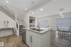 Open-concept living space with wood-finish flooring throughout - 