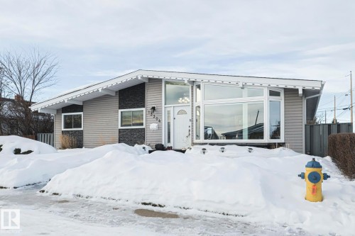 Mid-century modern facade featuring horizontal siding and stone accent panels - 13304 70 Street, Edmonton, AB 