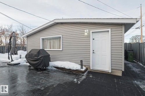 Detached garage with horizontal siding, a single window, and an exterior side door - 13304 70 Street, Edmonton, AB 