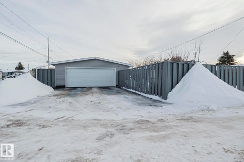 Detached garage featuring horizontal siding and a white sectional overhead door - 13304 70 Street, Edmonton, AB 