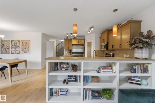 Kitchen featuring wood-finish cabinetry, stainless steel appliances, and a tiled backsplash - 2696 Anderson Crescent, Edmonton, AB - Indoor