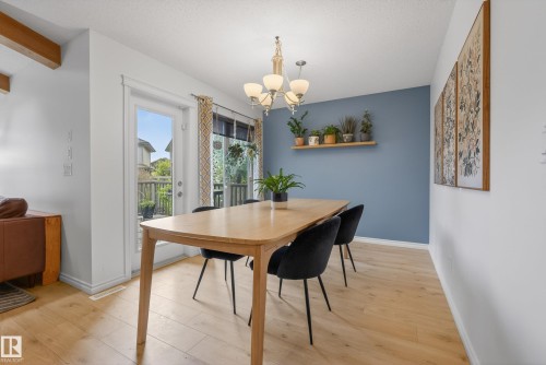 Dining area featuring light wood-finish flooring and a contemporary chandelier - 2696 Anderson Crescent, Edmonton, AB - Indoor Photo Showing Dining Room