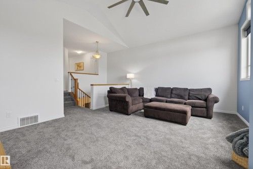 Carpeted living area featuring a vaulted ceiling and a ceiling fan - 2696 Anderson Crescent, Edmonton, AB - Indoor