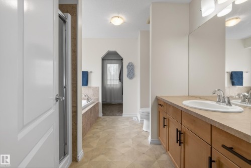Double vanity with integrated sinks and wood-finish cabinetry - 2696 Anderson Crescent, Edmonton, AB - Indoor Photo Showing Bathroom