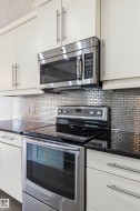 Kitchen featuring stainless steel appliances, including an electric range with a smooth cooktop and an over-the-range microwave - 