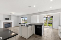 Open-concept living area featuring a kitchen island with black countertops and an integrated sink - 