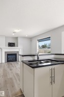 Kitchen island with dark countertops and a double basin sink, featuring a polished chrome faucet - 