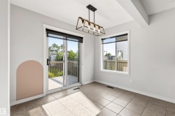 Ceramic tile flooring, a sliding glass door leading to a wooden deck, a rectangular window, and a linear pendant light fixture - 