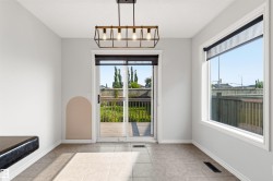 Bright dining space featuring a sliding glass door to the deck and a large window - 