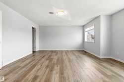 Spacious room featuring wood-finish flooring and neutral wall tones - 