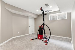 Spacious room featuring neutral painted walls, gray carpet flooring, white trim, and a white interior door - 