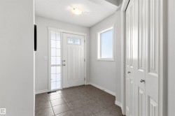 Entryway featuring a paneled door with decorative glass, a sidelight, and a window - 