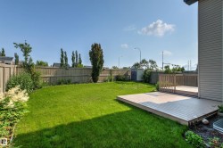 Expansive green lawn with a wood fence perimeter - 