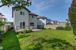 Expansive backyard featuring a manicured lawn, full-height privacy fencing, and a wooden deck - 