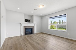Living area featuring a fireplace with a white mantel and tile surround - 