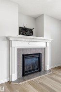 Fireplace featuring a white mantel, gray tile surround, and a black firebox - 