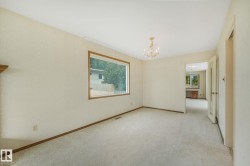 Carpeted room with a large window featuring wood trim - 