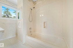 Bathroom featuring a tub/shower combination with a hand-held shower head, chrome fixtures, and a built-in soap dish - 