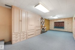 Spacious room featuring extensive built-in cabinetry, a stone-clad fireplace, and recessed window seating - 