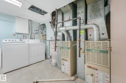 Utility room featuring two furnaces, a hot water heater, and a washer and dryer set - 