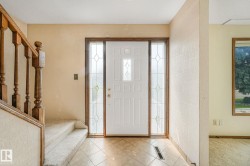Entryway featuring a white paneled door with decorative glass inserts, flanked by matching sidelight windows - 