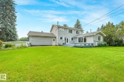 Expansive green lawn with a two-story residence featuring light gray siding - 